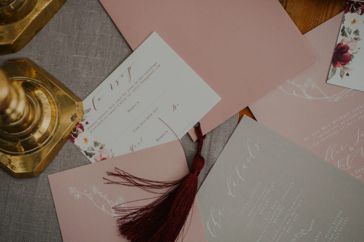 The wedding invitation suite was done in blush and sage green with blush and burgundy blooms