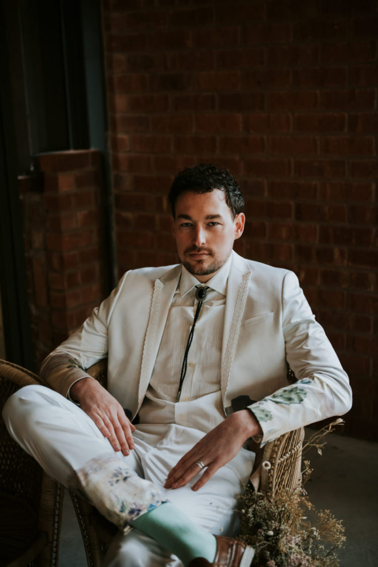 The groom was rocking a creamy suit with lace touches and painted floral and cactus on sleeves and pants