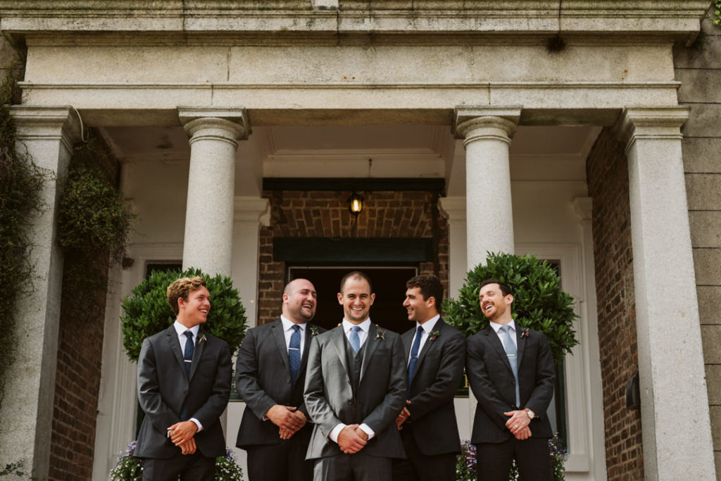 The groom was wearing a grey three piece suit and a blue tie, and the groomsmen were rocking two piece suits in the same color