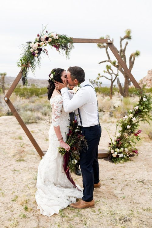 a boho hexagon wedding arch with greenery and grasses, blusha nd burgundy blooms for a boho fall wedding