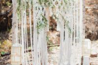 04 a cool macrame wedding backdrop with greenery interwoven and catchy geometric candle lanterns