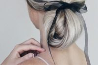 05 a twisted long and low ponytail turned into a low updo with an ethereal and sheer black ribbon for an accent without much drama