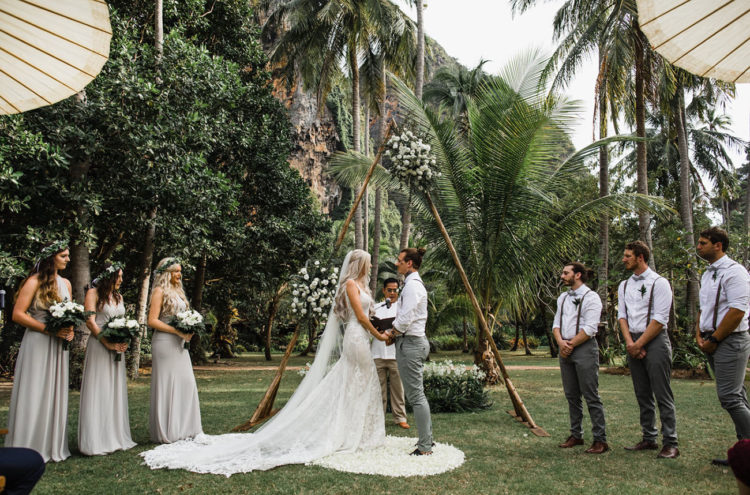 The second ceremony space was done with a triangle arch decorated with white florals and greenery and macrame rugs