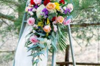 07 The wedding decor was done with a ladder, colorful blooms, candles and airy fabric