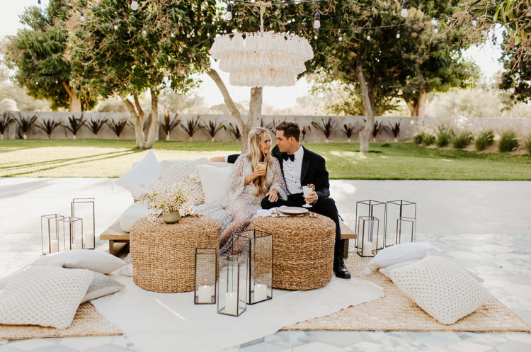 The wedding lounge was done boho, with a tassel chandelier, neutral pillows and jute ottomans