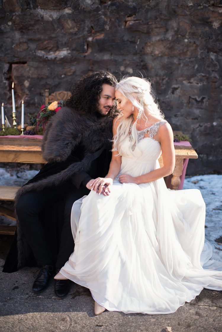 a Daenerys inspired bridal outfit with a draped wedding dress with an embellished neckline and a braided half updo
