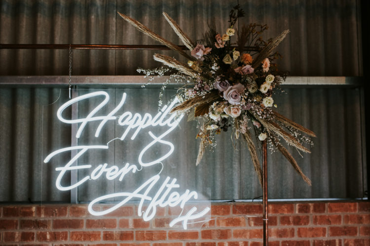 Neon signs are actual for boho weddings, they add brightness and interest to the space
