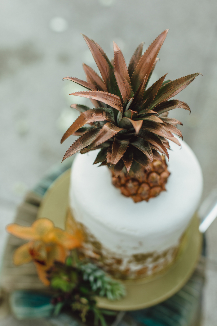 The wedding cake was a white one decorated with copper and with a copper pineapple topper