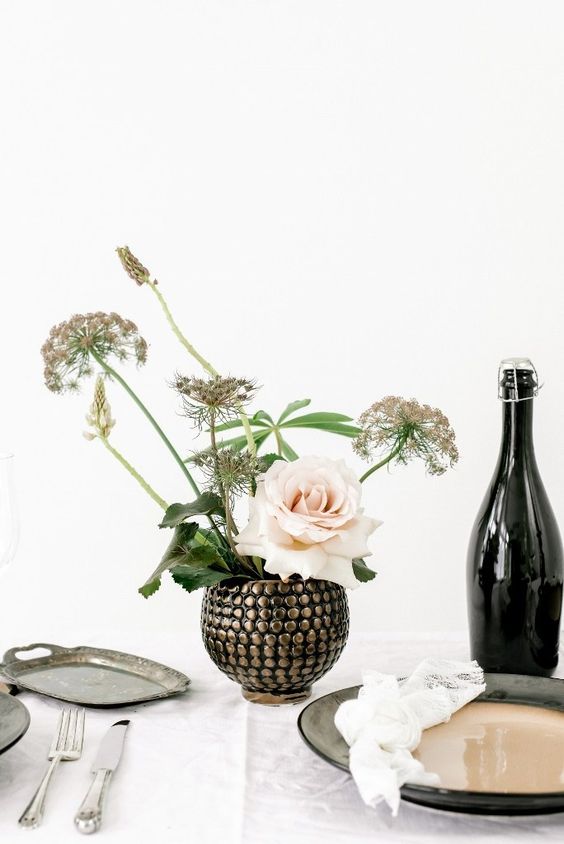 a very catchy embellished round vase with some dried blooms and a single blush roses has a big impact