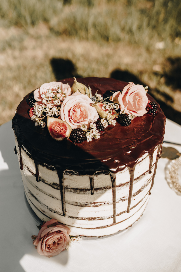 The wedding cake was a semi naked one with chocolate drip, fresh blooms and berries