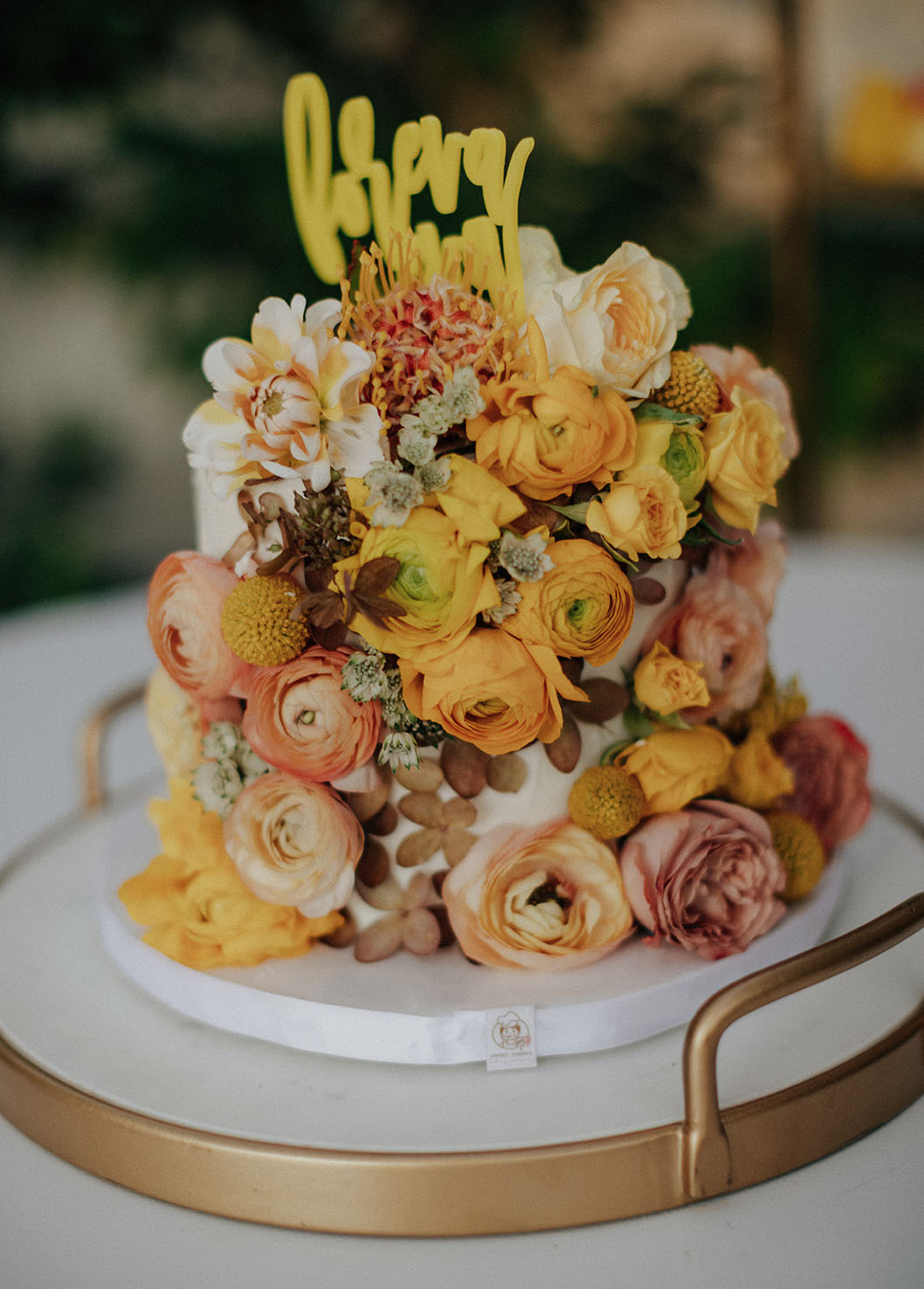 The wedding cake was very whimsy, it was all covered with yellow and rust blooms plus a calligraphy topper