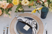 11 The wedding tablescape was done with lush florals, copper chargers, black and grey plates and navy glasses