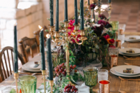 11 a luxurious wedding tablescape with bold lush florals, black candles in gold candle holders, greenery, fruits and berries plus copper mugs