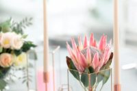 12 a single king protea inserted into a geometric candle holder and some candles in taller candle holders
