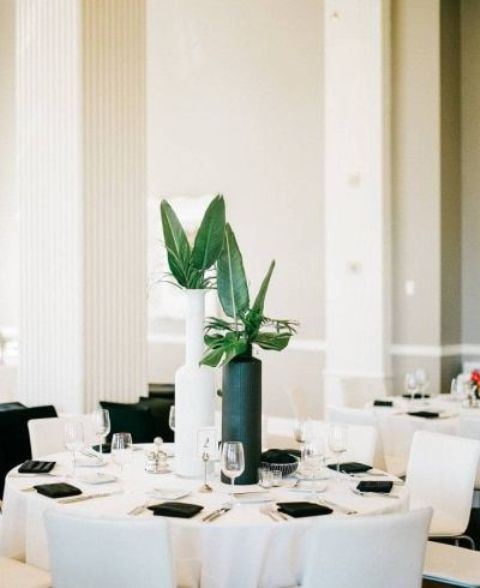 a black and white vase with tropical leaves is a chic and bold idea for a minimalist tropical wedding