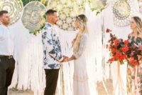 14 a wedding backdrop of oversized macrame dreamcatchers plus greenery and bright blooms for a boho wedding