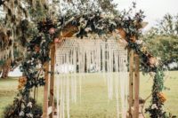 16 a boho wedding arch with macrame and fringe, lush greenery and pink and white blooms