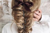 21 a dimensional fishtail braid with a bump and a brown ribbon bow plus a chain to accent the hairstyle