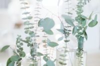 22 a minimalist wedding centerpiece with clear vases and fresh eucalyptus is a stylish and refreshing idea