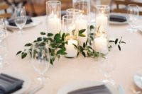 24 a group of candles with greenery is a chic minimalist wedding centerpiece that creates a cozy ambience at the table