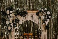 24 a tropical wedding arch with macrame, lush white tropical blooms and tropical leaves