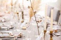 a beautiful neutral winter wedding tablescape with a grey tablecloth, cotton, dried blooms, candles and grass is awesome