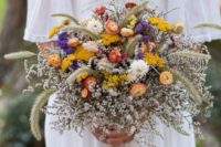 a bright wedding bouquet with white fresh blooms, dried yellow, purple and rust flowers and dried wheat