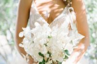 a chic and ethereal lunaria wedding bouquet with some berries and neutral ribbons for a spring bride
