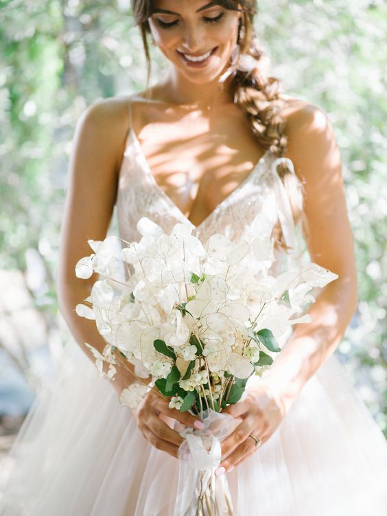 a chic and ethereal lunaria wedding bouquet with some berries and neutral ribbons for a spring bride
