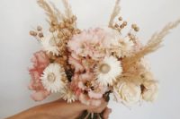 a delicate and subtle wedding bouquet of white and blush blooms, seed pods and wheat is a very romantic idea