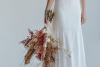 a gorgeous boho wedding bouquet with dried blooms, herbs, branches and berries plus delicate silk ribbons
