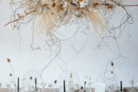 a gorgeous overhead arrangement of cotton branches, pampas grass, seed pods, dried blooms and herbs