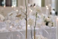 a minimalist wedding centerpiece of a brass bud vase, white roses and lunaria is a cool idea for a minimalist wedding