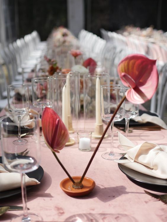 a minimalist wedding centerpiece of a plate with pink anthurium is a cool idea for a bold wedding
