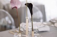 a minimalist wedding centerpiece of gold bud vases and various anthuriums is a cool idea for a modern or minimal wedding