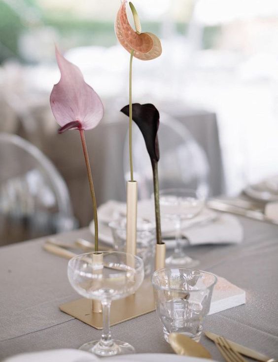 a minimalist wedding centerpiece of gold bud vases and various anthuriums is a cool idea for a modern or minimal wedding