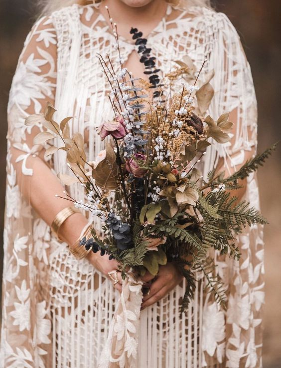 a refined fall wedding bouquet made of ferns, dried foliage, blooms and berries is a gorgeous boho idea