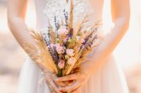 a rustic boho wedding bouquet with wheat, lavender and little blush roses is a cute idea for summer or fall