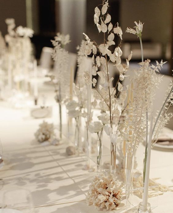 gorgeous minimalist white wedding centerpieces of bud vases and white blooms and leaves are amazing for white weddings