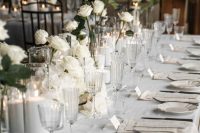 minimalist white wedding centerpieces of roses and pillar candles are amazing for a minimalist wedding