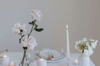 pretty minimalist wedding centerpieces of a clear glass vase with blush roses and a white vase with white blooms