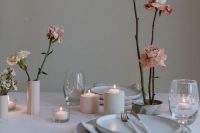 vases with pink roses and pillar candles are great minimalist wedding decor, you can make them yourself