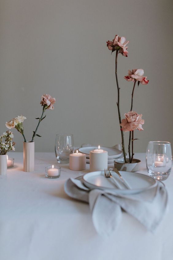 vases with pink roses and pillar candles are great minimalist wedding decor, you can make them yourself