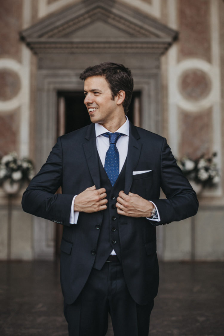 The groom was wearing a navy three-piece suit, a white shirt, a bright blue printed tie