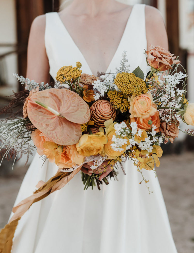 The fantastic wedding bouquet was done in rust, mustard and yellow shades and with pale greenery and herbs