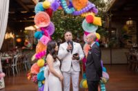 The wedding arch was done of colorful paper balls and fans for more color