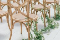 05 a modern wedding aisle done with simple wooden chairs and lush greenery climbing up the chairs is all you need for a cool look