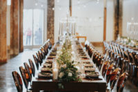 08 The wedding reception space was done with wooden tables, greenery and white blooms and elegant white candles
