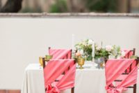 09 The wedding chairs were decorated with coral pink fabric that matched the napkins