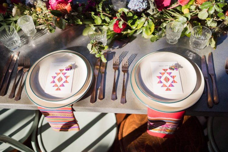 The wedding tablescape was done with bright Peruvian textiles, cards and bold florals